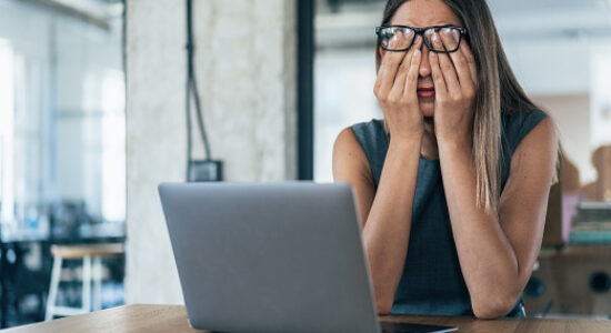 Business woman with hands on her face looking exhausted